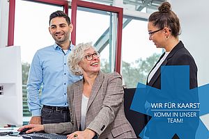 Drei Personen unterhalten sich freundlich im Büro; Text: "Wir für Kaarst – komm in unser Team!".