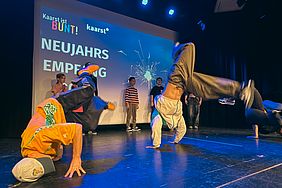 Eine Gruppe von Breakdancern führt auf der Bühne eine energiegeladene Performance auf.