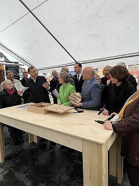 Eine Gruppe von Menschen vor einem langen Tisch.